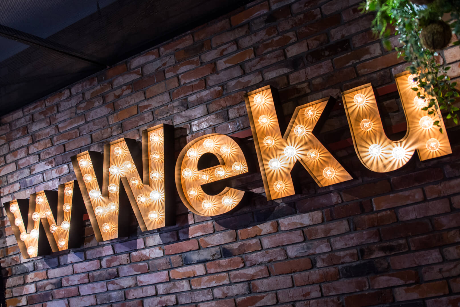 wWeku - letters met bollen op een bakstenen muur